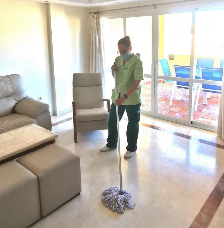 Empleada de Brócoli limpiando el suelo de la habitación de un hotel