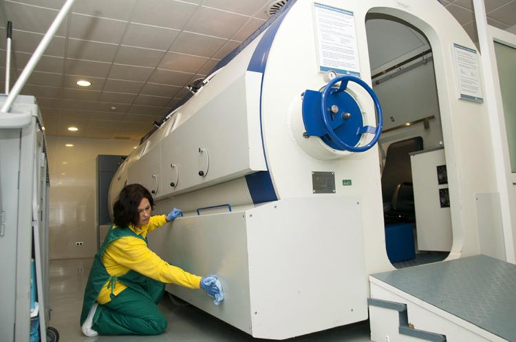 Mujer limpiando maquinaria en un hospital
