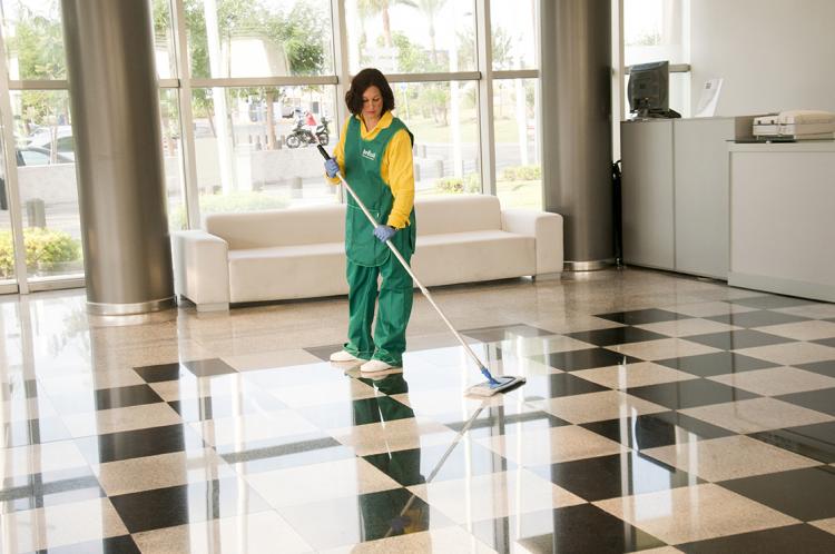 Una empleada de BCL limpiando el suelo de una recepción de una empresa