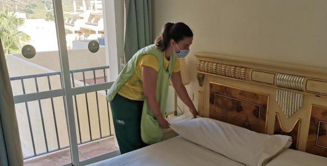 Empleada de Brócoli preparando la cama de un hotel