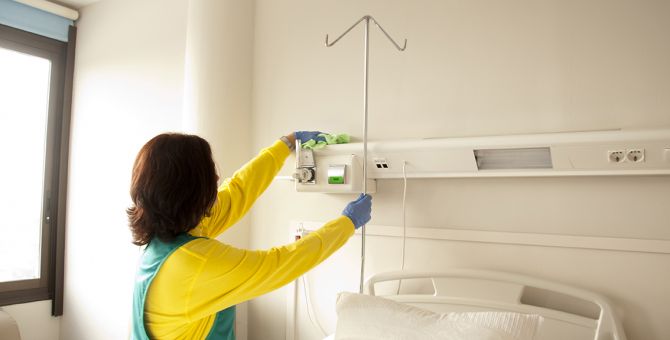 Mujer limpiando una habitación de un hospital