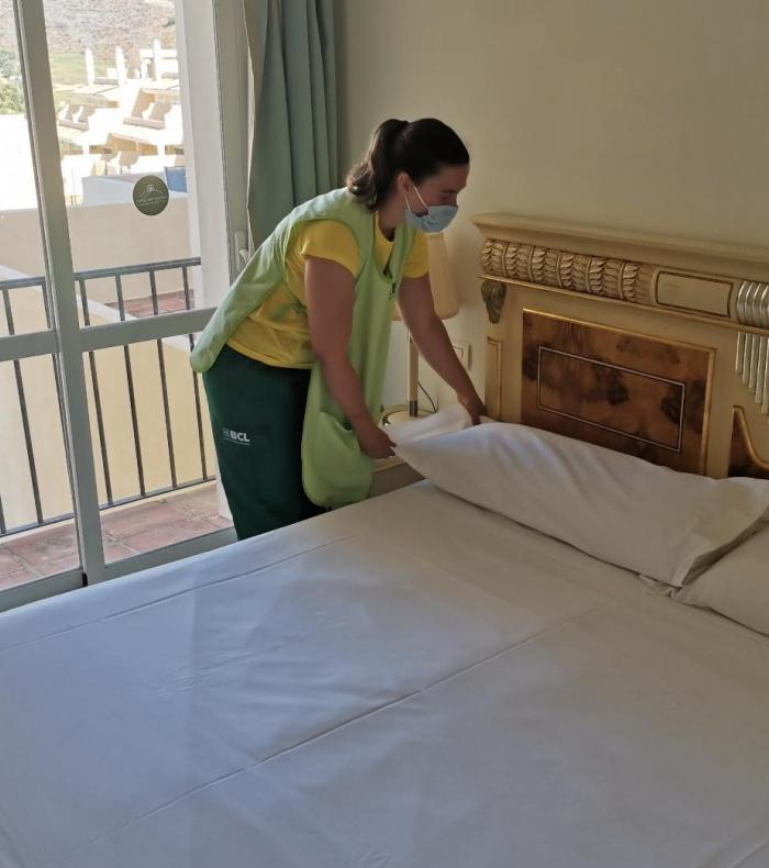 Empleada de Brócoli preparando la cama de un hotel